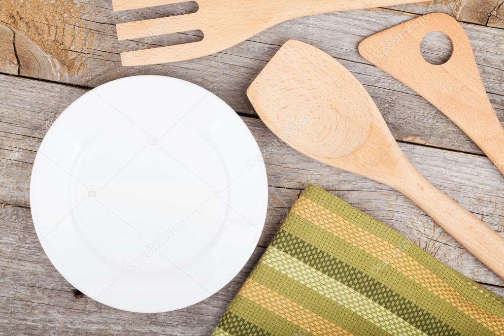 Empty plate and utensils on wood table