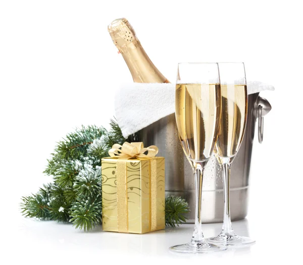 Бутылка шампанского в ведре со льдом, два бокала и рождественский подарок — стоковое фото