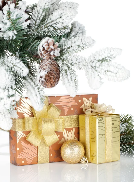 Gift box and christmas decor under snowy fir tree — Stock Photo, Image