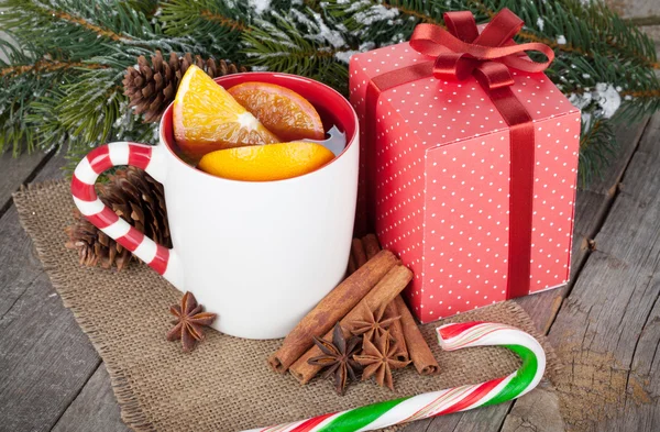 Christmas mulled wine with spices, gift box and snowy fir tree — Stock Photo, Image