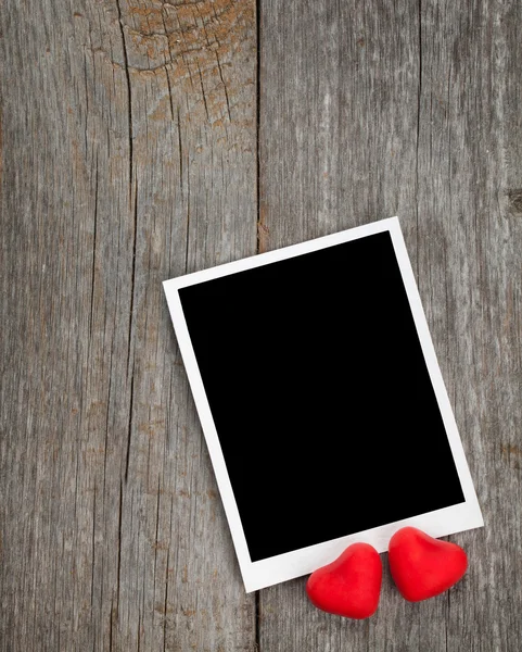 Photo frame and small red candy hearts — Stock Photo, Image