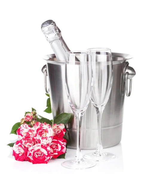 Champagneflaska, två glasögon och röda rosa blommor — Stockfoto