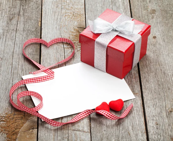 Tarjeta de felicitación de San Valentín en blanco y pequeña caja de regalo roja Imagen de archivo
