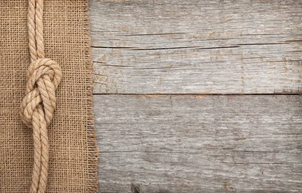 Ship rope on wood and burlap texture background — Stock Photo, Image