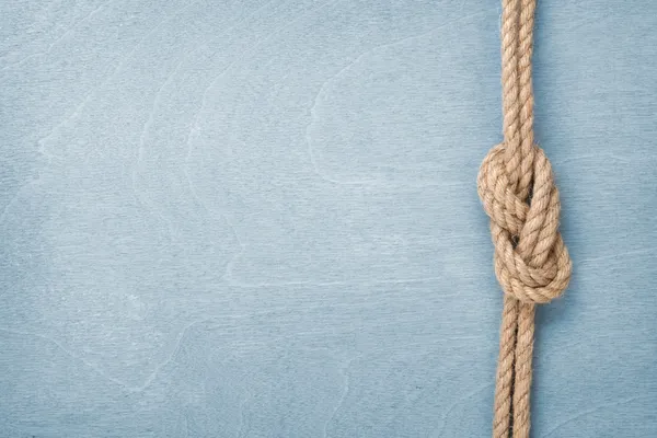 Ship rope knot on wooden texture background — Stock Photo, Image