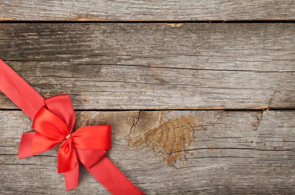 Wooden background with red bow and ribbon — Stock Photo, Image