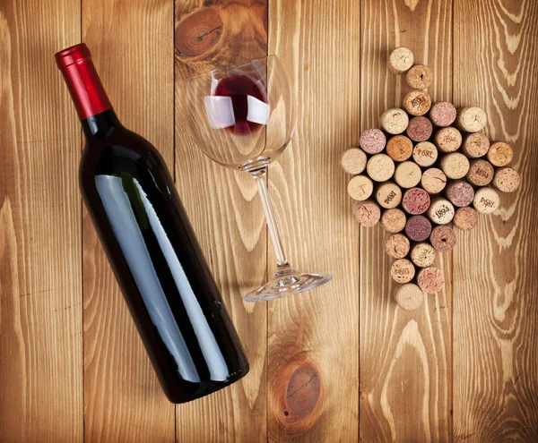 Red wine bottle, glass and grape shaped corks — Stock Photo, Image