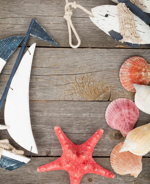 Zabawka żaglówkę i ryb, muszle i rozgwiazdy — Zdjęcie stockowe