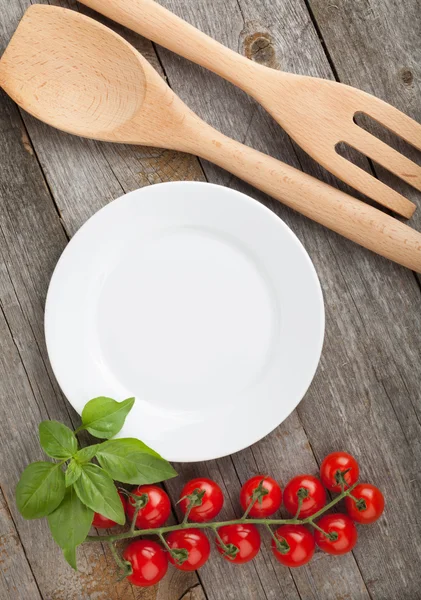 Пустая тарелка на дереве с помидорами — стоковое фото