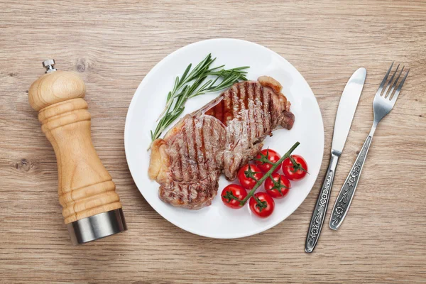 Bistecca di Sirloin con rosmarino e pomodorini su un piatto — Foto Stock