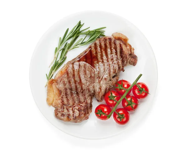 Bife de lombo com alecrim e tomate cereja em uma chapa — Fotografia de Stock