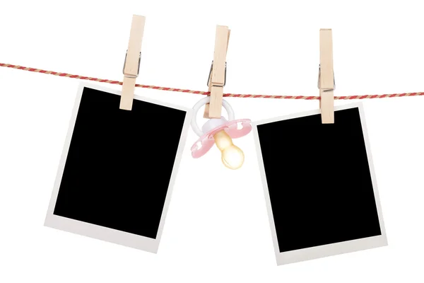 Instant photo frames and pacifier hanging on the clothesline — Stock Photo, Image