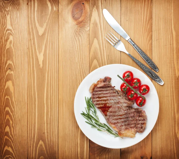 Bife de lombo com alecrim e tomate cereja em uma chapa — Fotografia de Stock