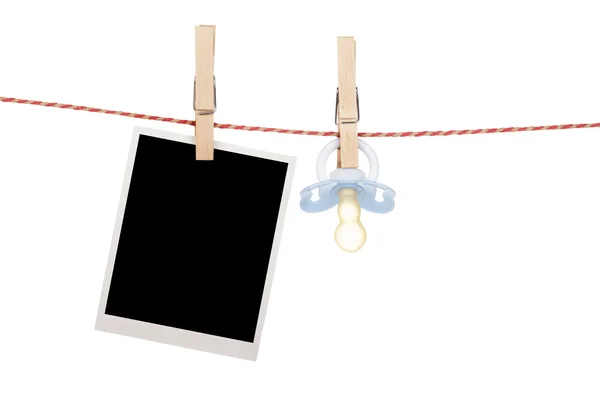 Instant photo and pacifier hanging on the clothesline — Stock Photo, Image