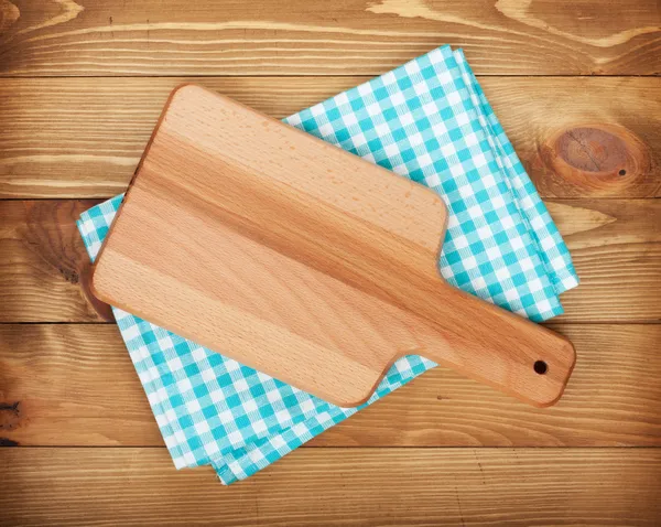 Cutting board over kitchen towel — Stock Photo, Image