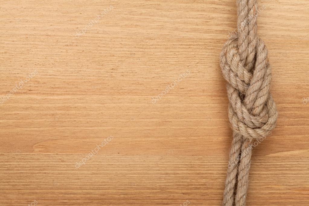 Ship rope knot on wooden texture background Stock Photo by ©karandaev  42043521