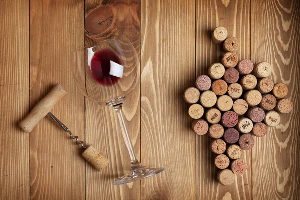 Copa de vino tinto, sacacorchos y corchos en forma de uva — Foto de Stock