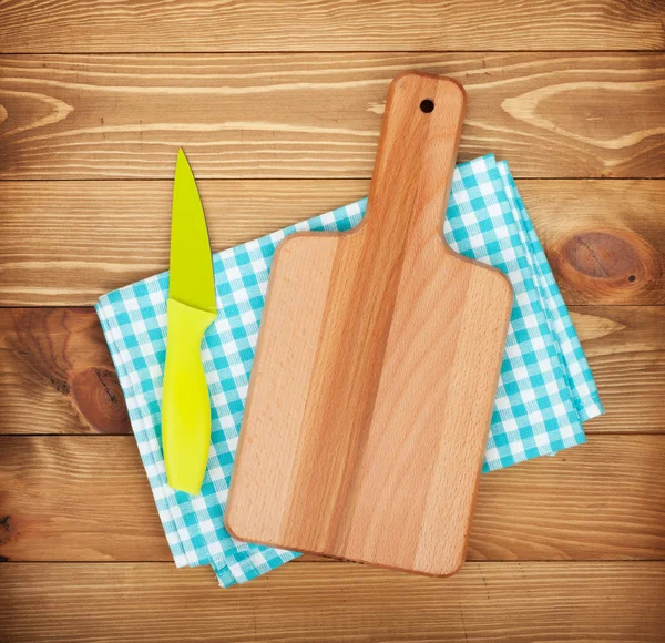 Cutting board and knife over kitchen towel — Stock Photo, Image