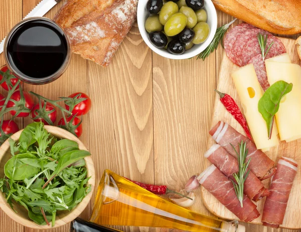 Red wine with cheese, olives, tomatoes, prosciutto, bread and spices — Stock Photo, Image