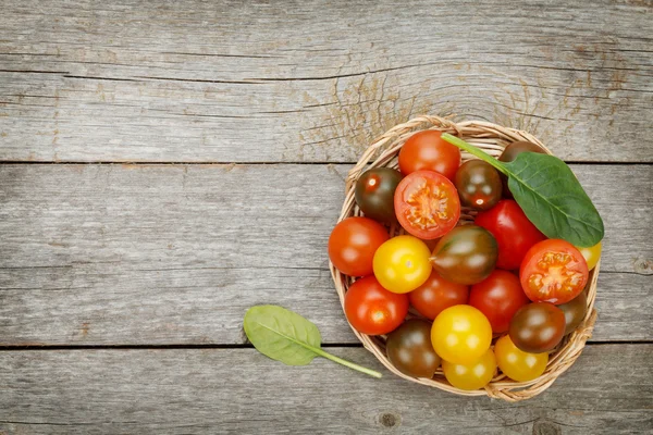 Kleurrijke cherry tomaten op houten tafel — Stockfoto