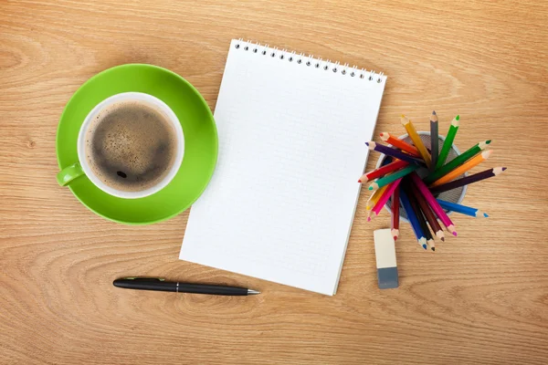 Bloco de notas em branco com material de escritório e xícara de café verde — Fotografia de Stock