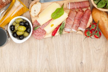 Kırmızı şarapla peynir, zeytin, domates, salam, ekmek ve baharatlar