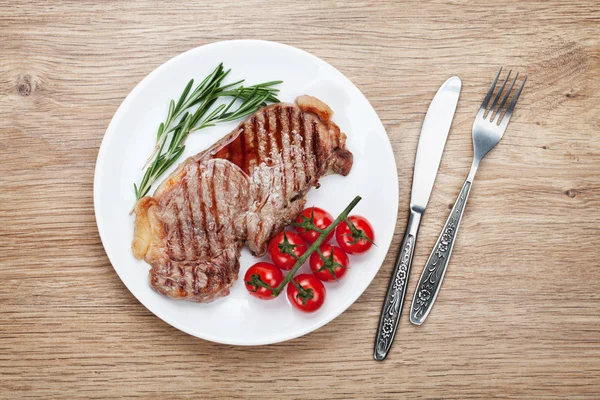 Sirloin steak with rosemary and cherry tomatoes on a plate — Stock Photo, Image