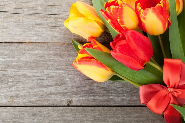 Fresh colorful tulips with ribbon and bow — Stock Photo, Image