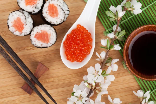 Красная икра, набор суши, ветвь сакуры и палочки для еды — стоковое фото