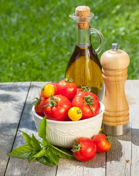 Tomates fraîches mûres, bouteille d'huile d'olive, poivrier et herbes — Photo