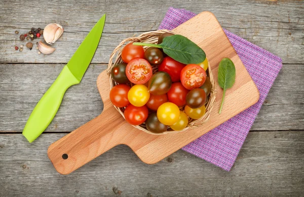 Tomates cereja coloridos na mesa de madeira — Fotografia de Stock