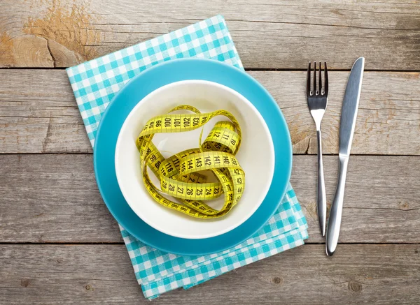 Plate with measure tape, knife and fork. — Stock Photo, Image