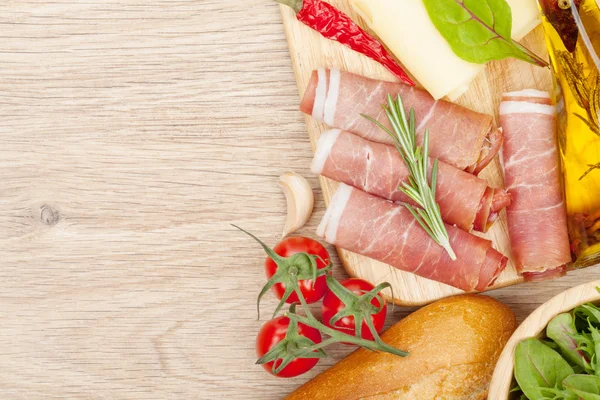 Cheese, prosciutto, bread, vegetables — Stock Photo, Image