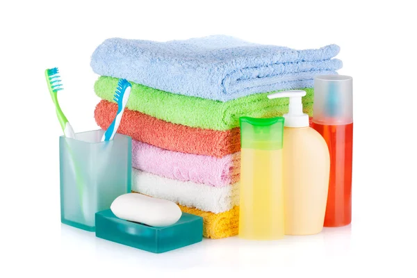 Two colorful toothbrushes, cosmetics bottles, soap and towels — Stock Photo, Image