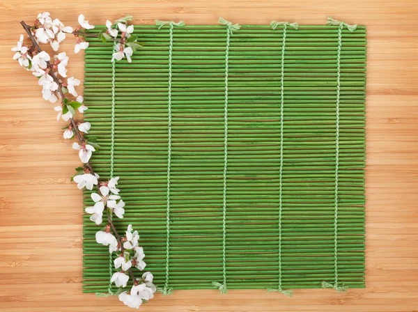 Sakura ramo sobre tapete de bambu — Fotografia de Stock