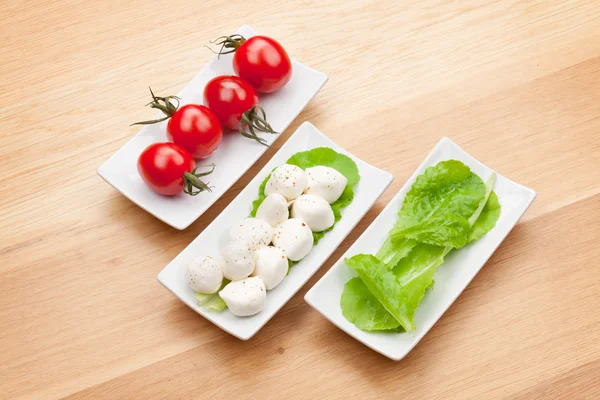 Tomaatit, mozzarella ja salaatti — kuvapankkivalokuva
