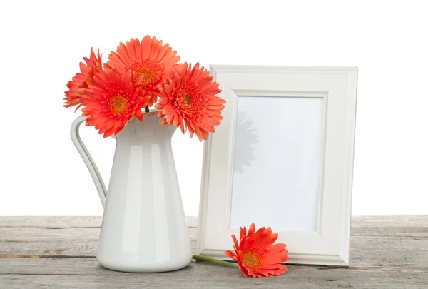 Orange gerbera flowers and photo frame on wooden table — Stock Photo, Image