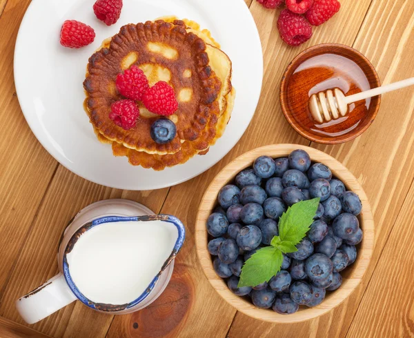 Pannenkoeken met frambozen, bosbessen, munt en honing siroop — Stockfoto