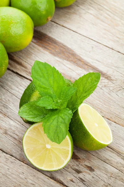 Frische reife Limetten mit Minze — Stockfoto