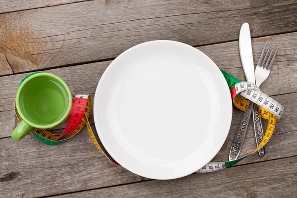 Plate with measure tape, cup, knife and fork — Stock Photo, Image