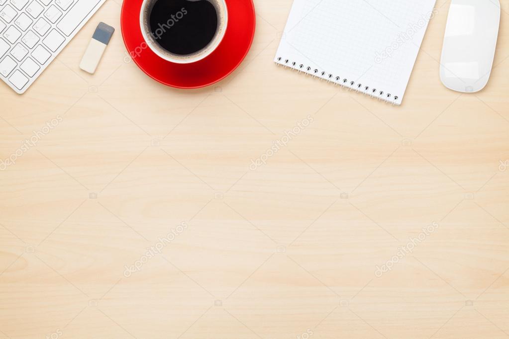 Office table with notepad, computer and coffee cup