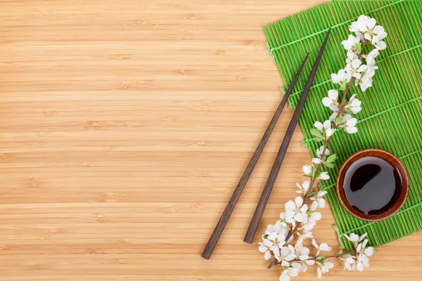 Chopsticks, sakura branch, soy sauce — Stock Photo, Image