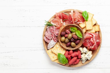 Prosciutto, salam, kraker, peynir ve zeytinli pansiyon. Üst görünüm düzlüğü kopyalama alanı ile yatıyordu