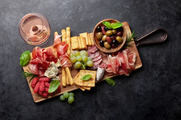 プロシクト サラミ クラッカー チーズ ナッツ オリーブ ローズワインとアンティパストボード 最上階平面 — ストック写真