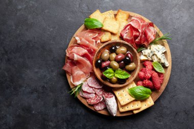 Prosciutto, salam, kraker, peynir ve zeytinli pansiyon. Üst görünüm düzlüğü kopyalama alanı ile yatıyordu