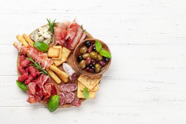 Prosciutto, salam, kraker, peynir ve zeytinli pansiyon. Üst görünüm düzlüğü kopyalama alanı ile yatıyordu