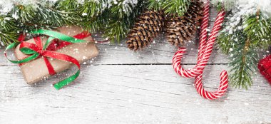 Kar köknar ağacı, hediye kutusu ve tahta masada şeker kamışı olan bir Noel arkaplanı. Üst görünüm düzlüğü