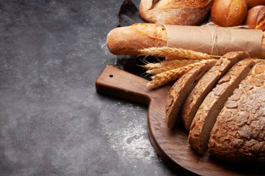 Taş masada çeşitli ekmek türleri. Kopyalama alanı ile
