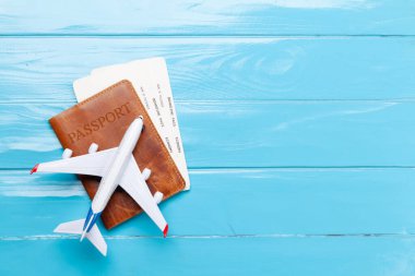 Seyahat ve tatil konsepti. Pasaportun üstünde uçak oyuncağı ve biletler. Aksesuarlar ve eşyalar. Üst görünüm düzlüğü kopyalama alanı ile yatıyordu