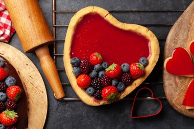 Kalp şeklinde böğürtlenli tatlı kek. Sevgililer Günü tebrik kartı. Üst görünüm düzlüğü